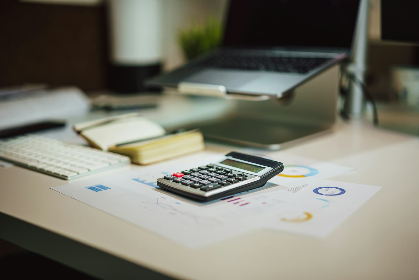 A calculator and paperwork on a desk for budgeting