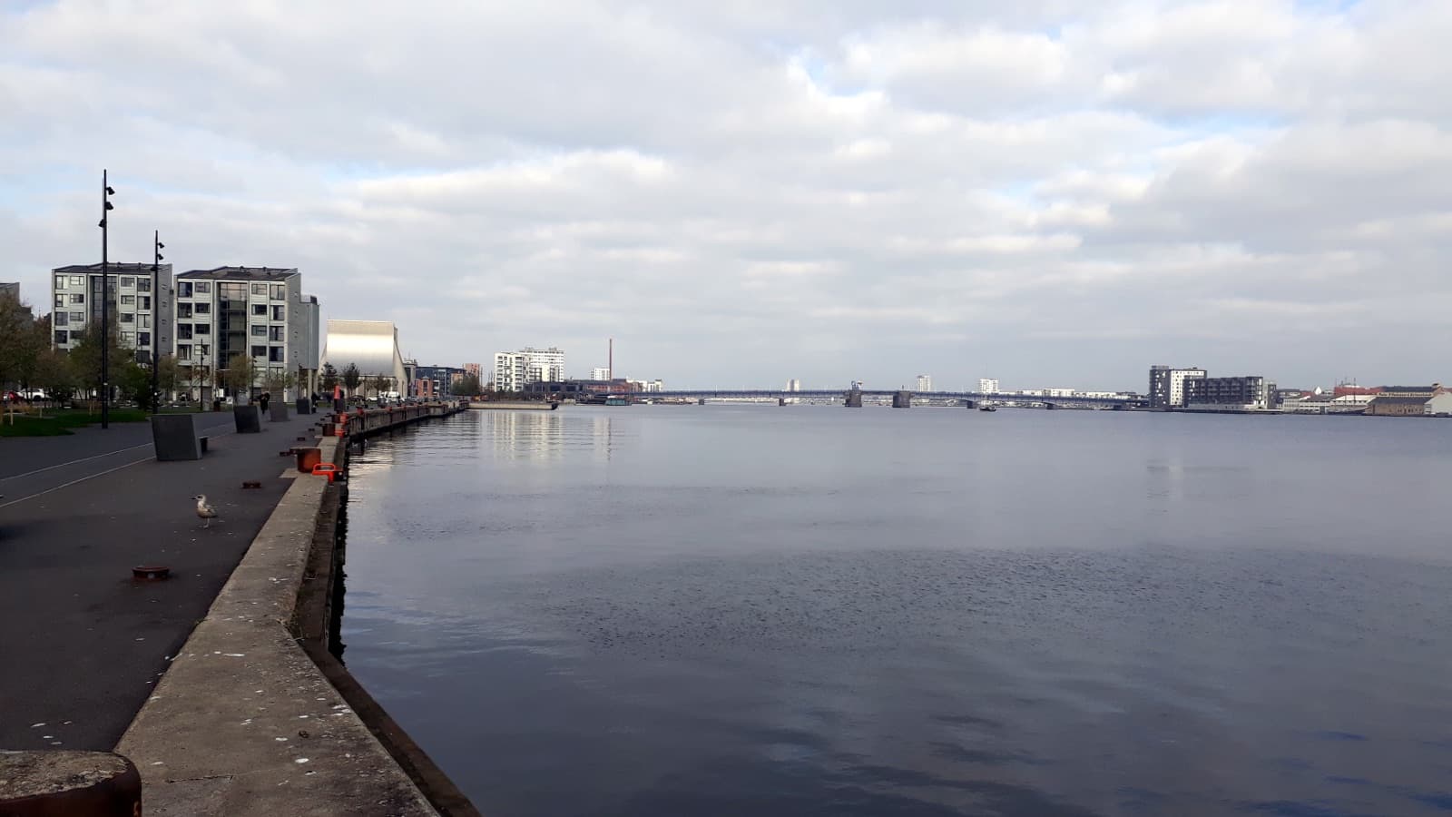 The Limfjord waterfront promenade in Aalborg Midtby, with the Utzon Center and the harbourfront apartments looking toward the bridge, Aalborg, Denmark.