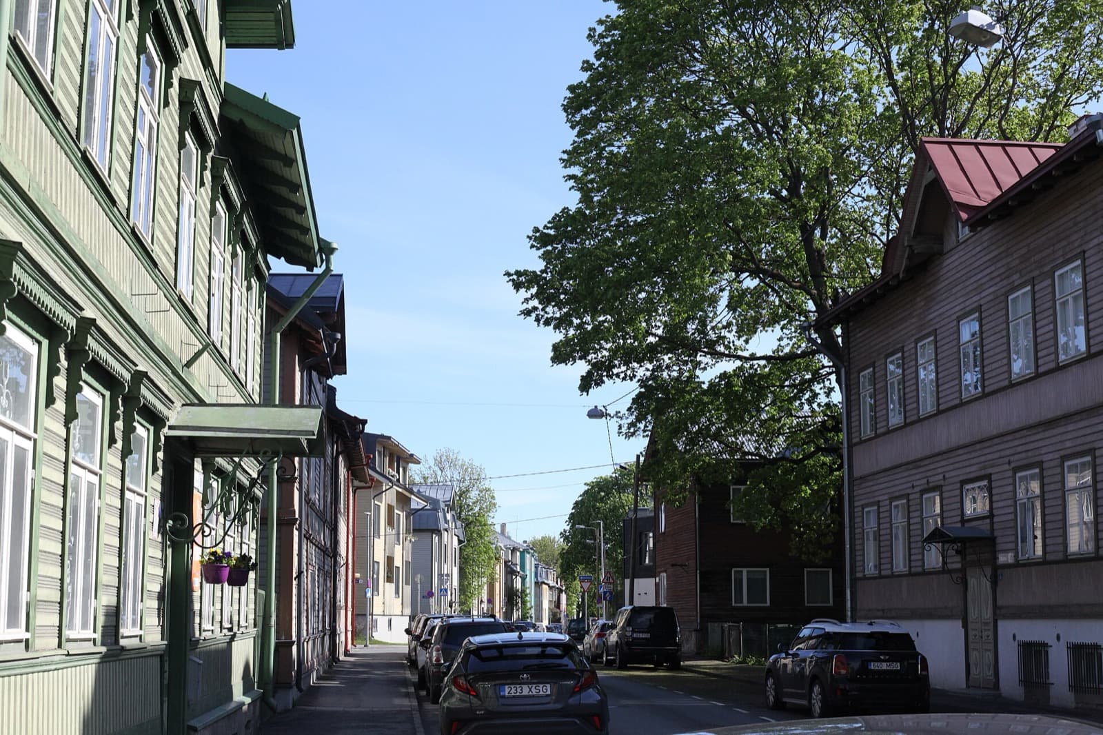 Colourful wooden houses lining Malmi street in Kalamaja on a sunny day.