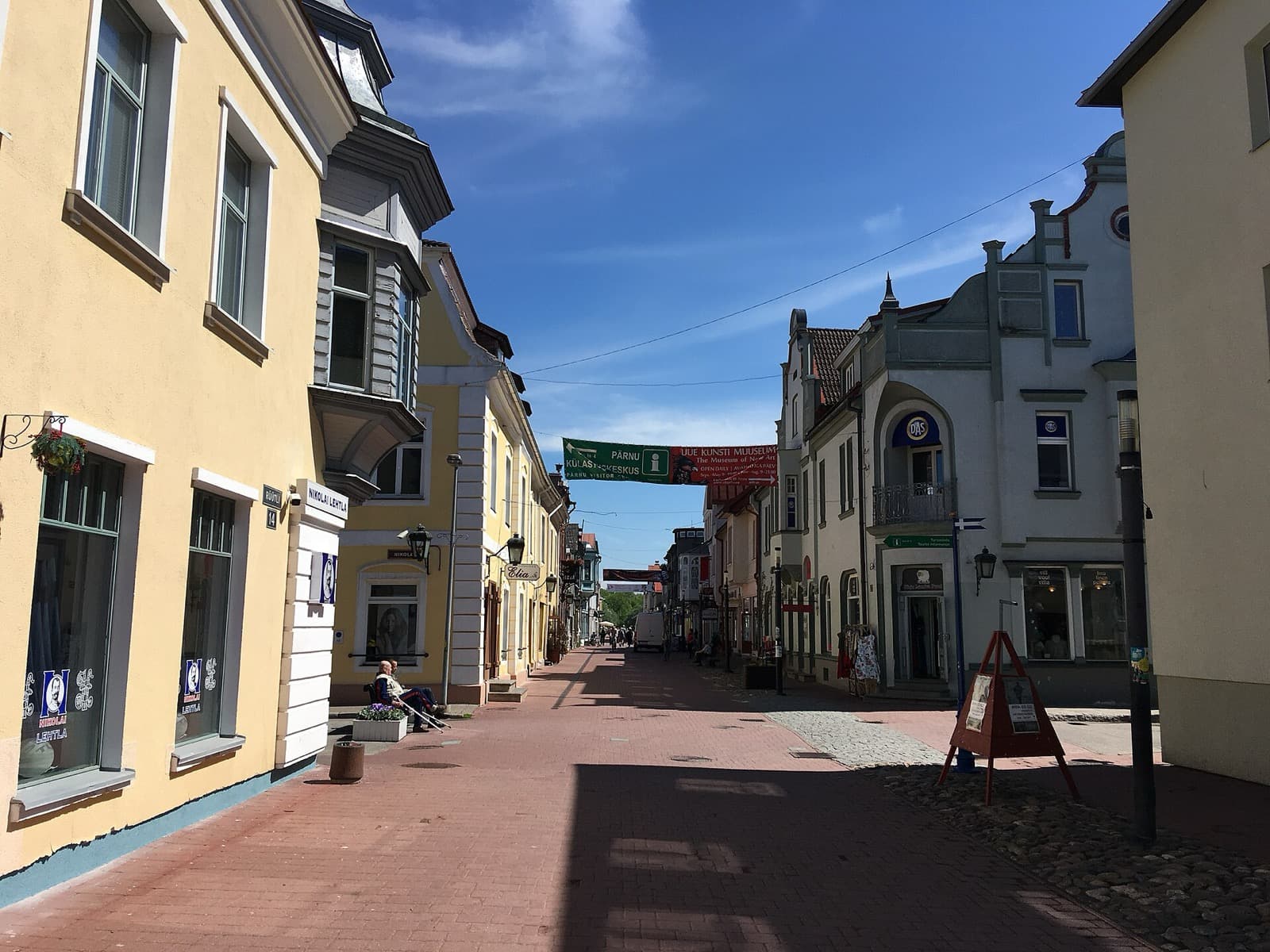 The pedestrian Rüütli street in central Pärnu, lined with pastel merchant houses on a sunny day