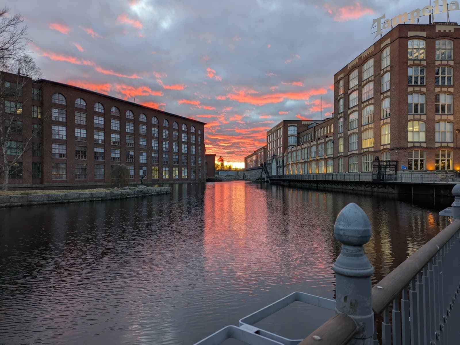 Sunset over the Tammerkoski rapids in central Tampere, with the red-brick Tampella mill buildings lining both banks.