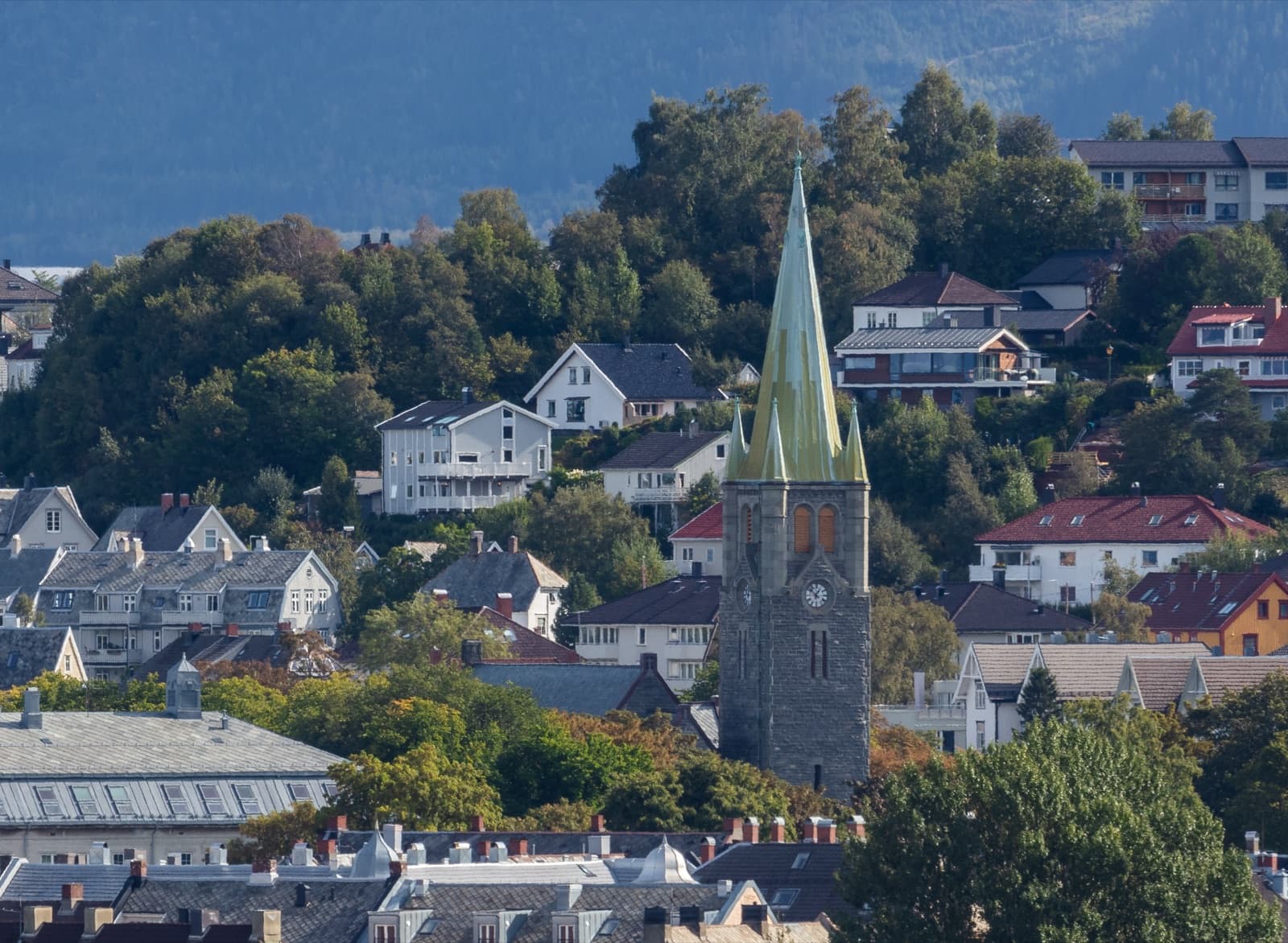 The copper spire of Lademoen church rising above the rooftops of the surrounding streets, Lademoen, Trondheim, Norway.