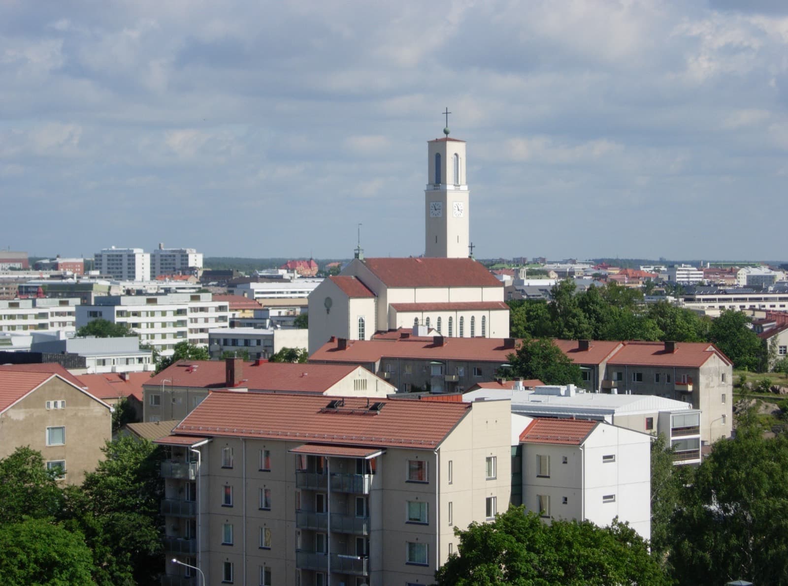 The red rooftops of Martti in Turku seen from above, with the white clock tower of St Martin's Church rising over the district.