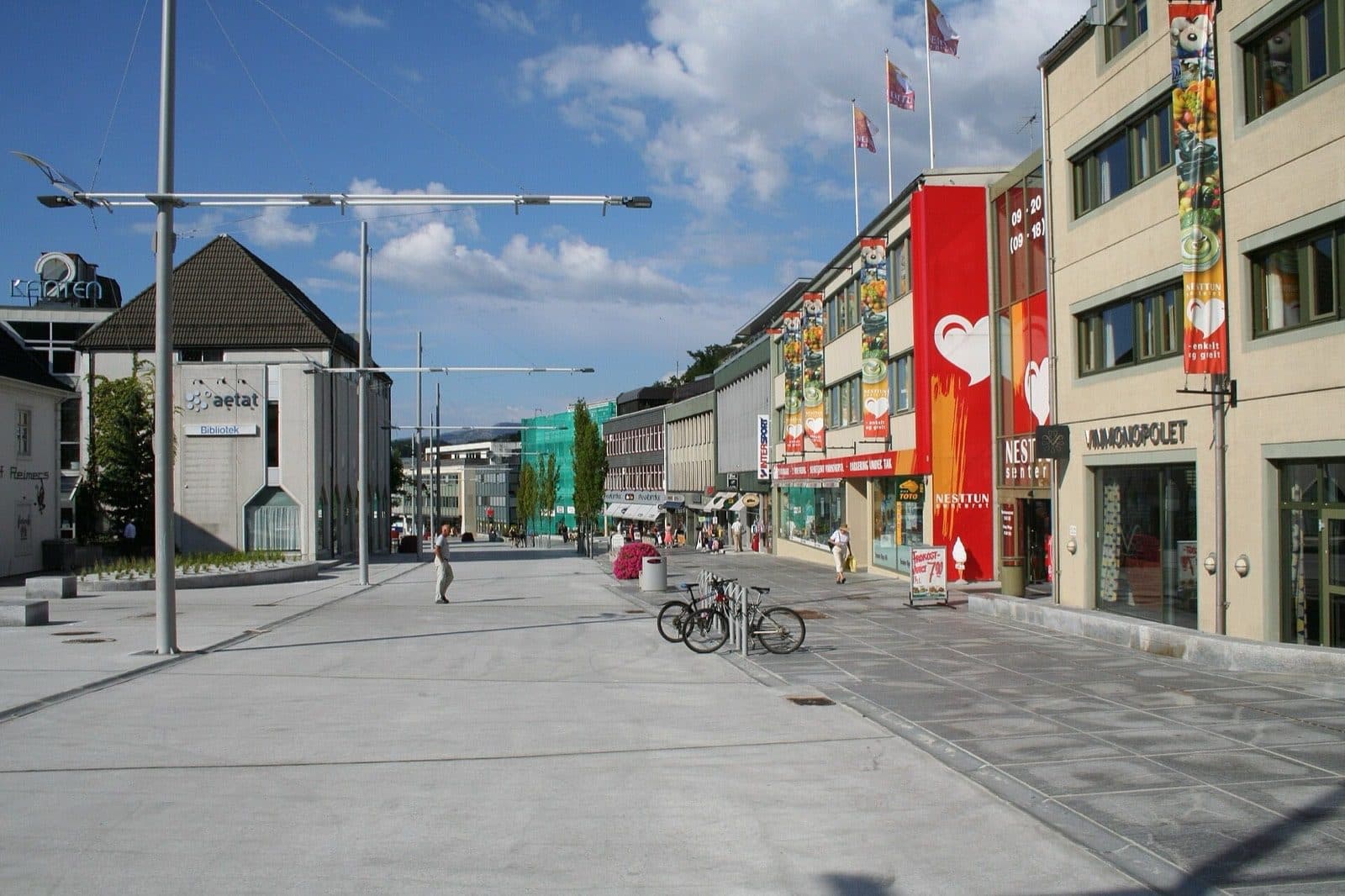 The pedestrianised high street in Nesttun, Bergen, on a sunny day, with the shopping centre and library along it.