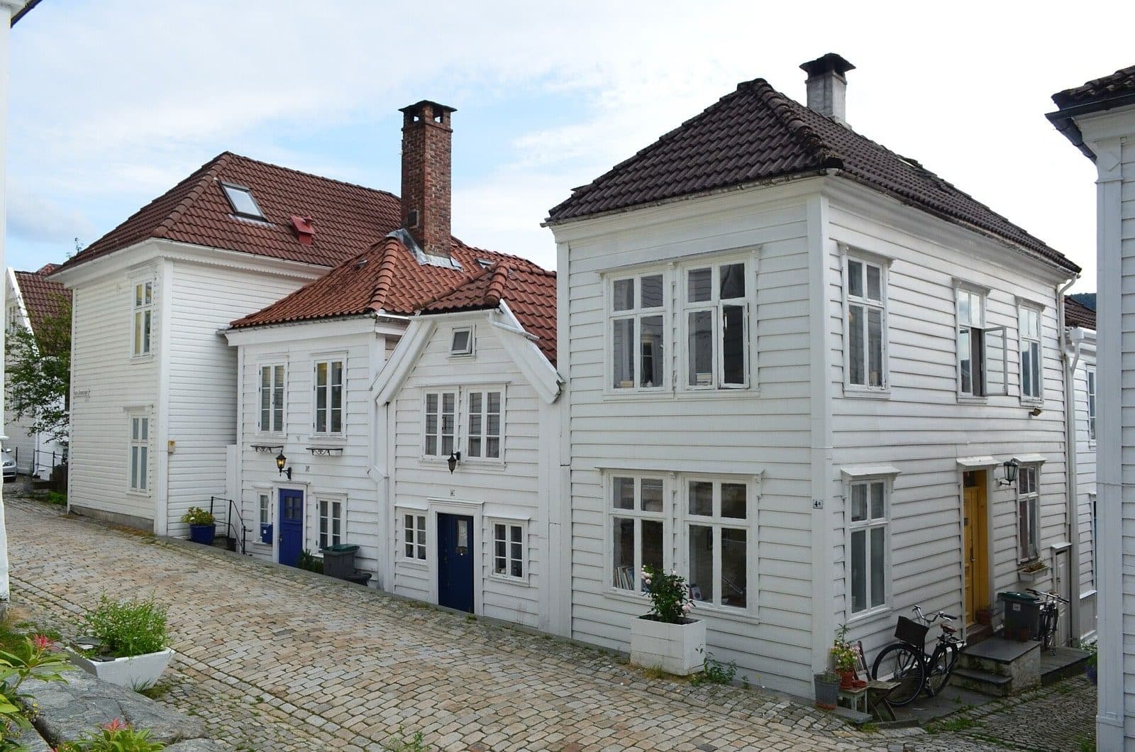 White painted timber houses along a cobbled lane on Nordnes in Bergen.