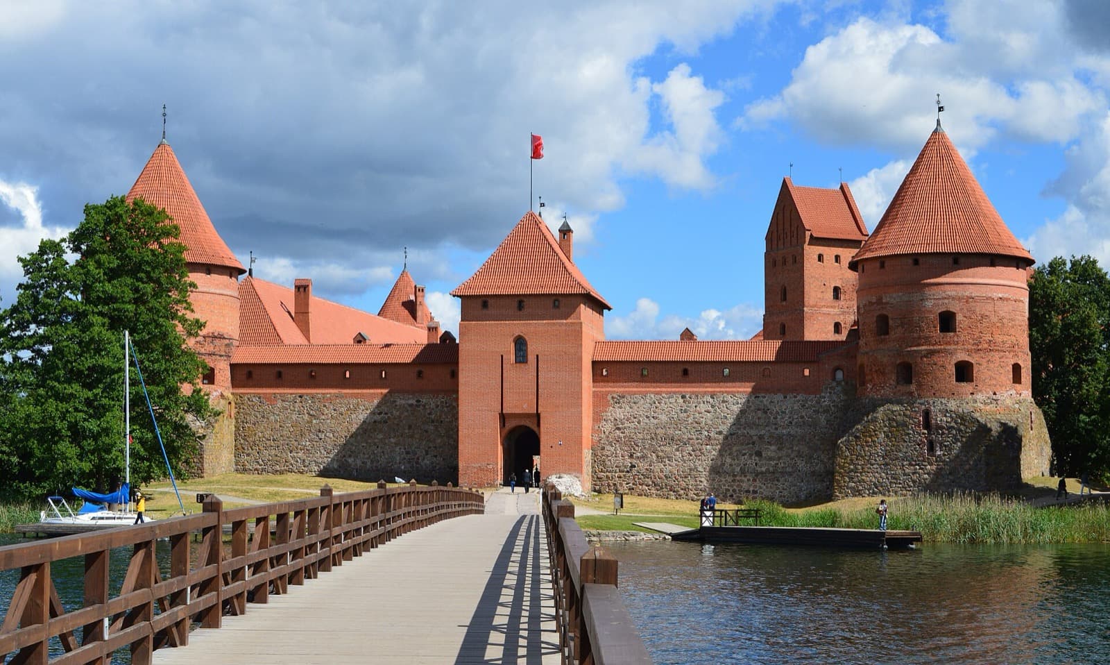 The wooden footbridge leading across the lake to the red-brick Trakai Island Castle.