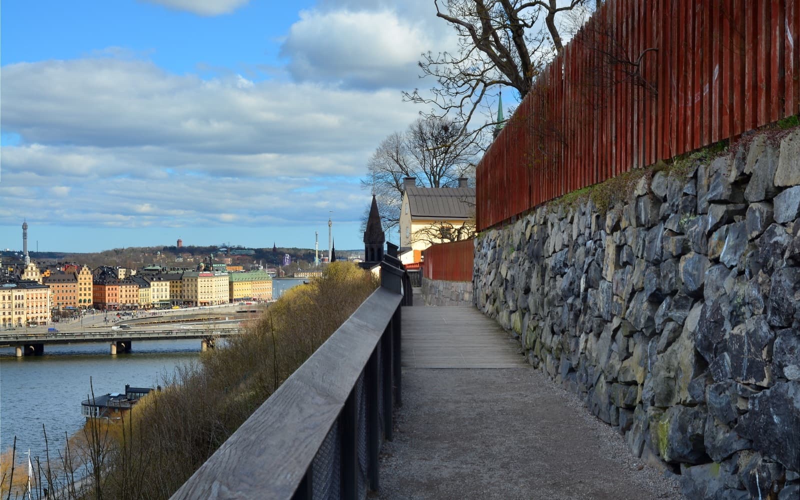 The Monteliusvägen cliff walk on Södermalm, looking across Riddarfjärden toward Gamla Stan and Stockholm City Hall.