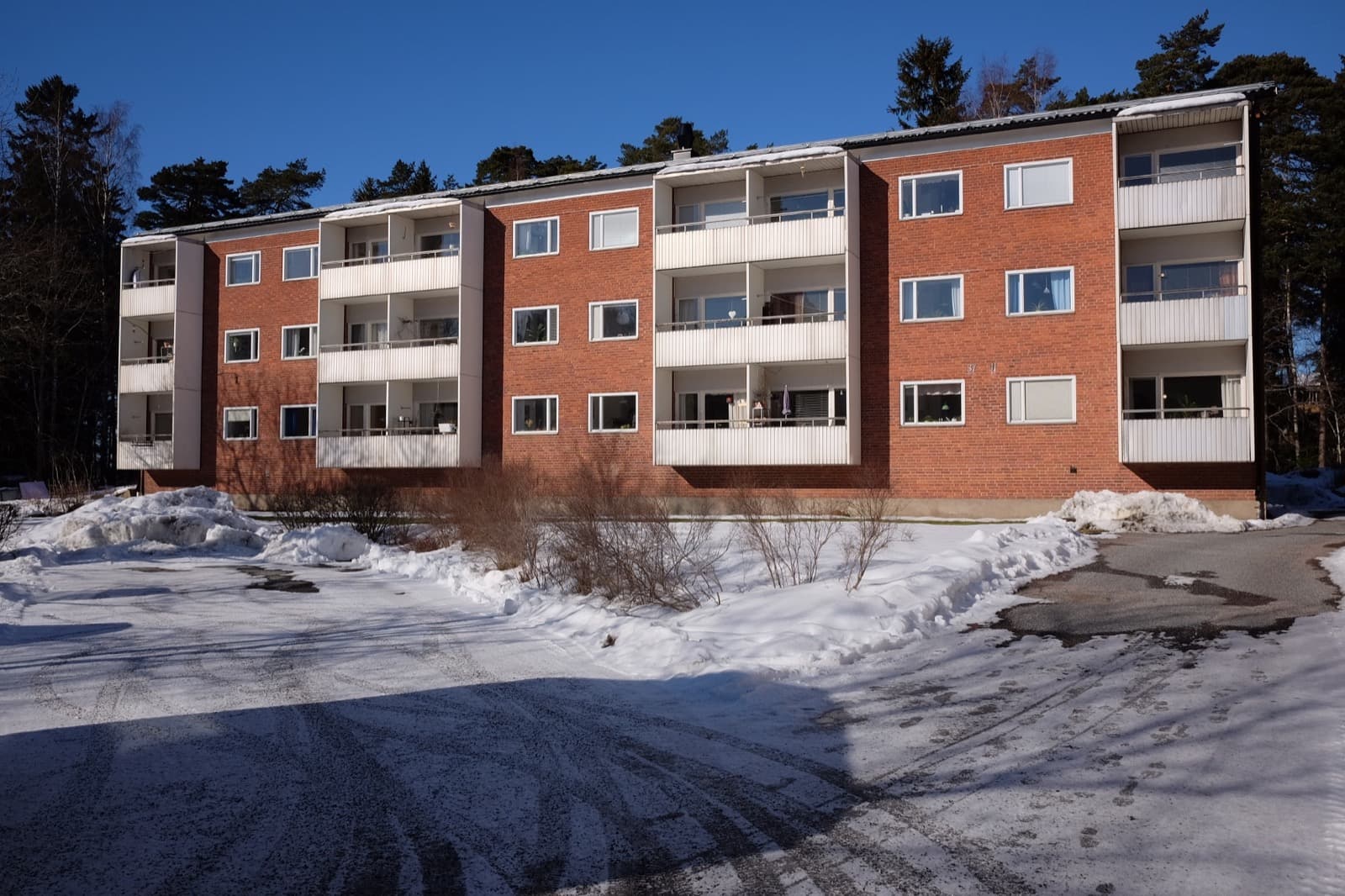 Residential blocks on Blodstensvägen among trees in the Eriksberg district of Uppsala, Sweden.