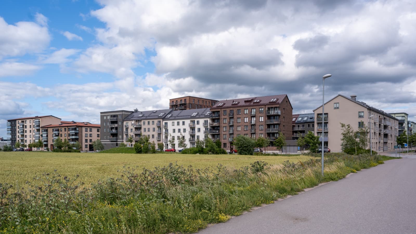 A residential street of new apartment blocks in Norra Luthagen, Uppsala, Sweden, on a summer day.