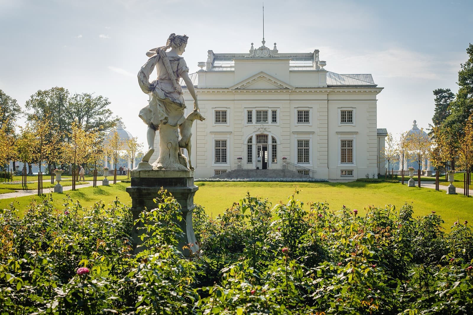 The white neoclassical Užutrakis manor house seen across its rose garden and landscaped park, Trakai.