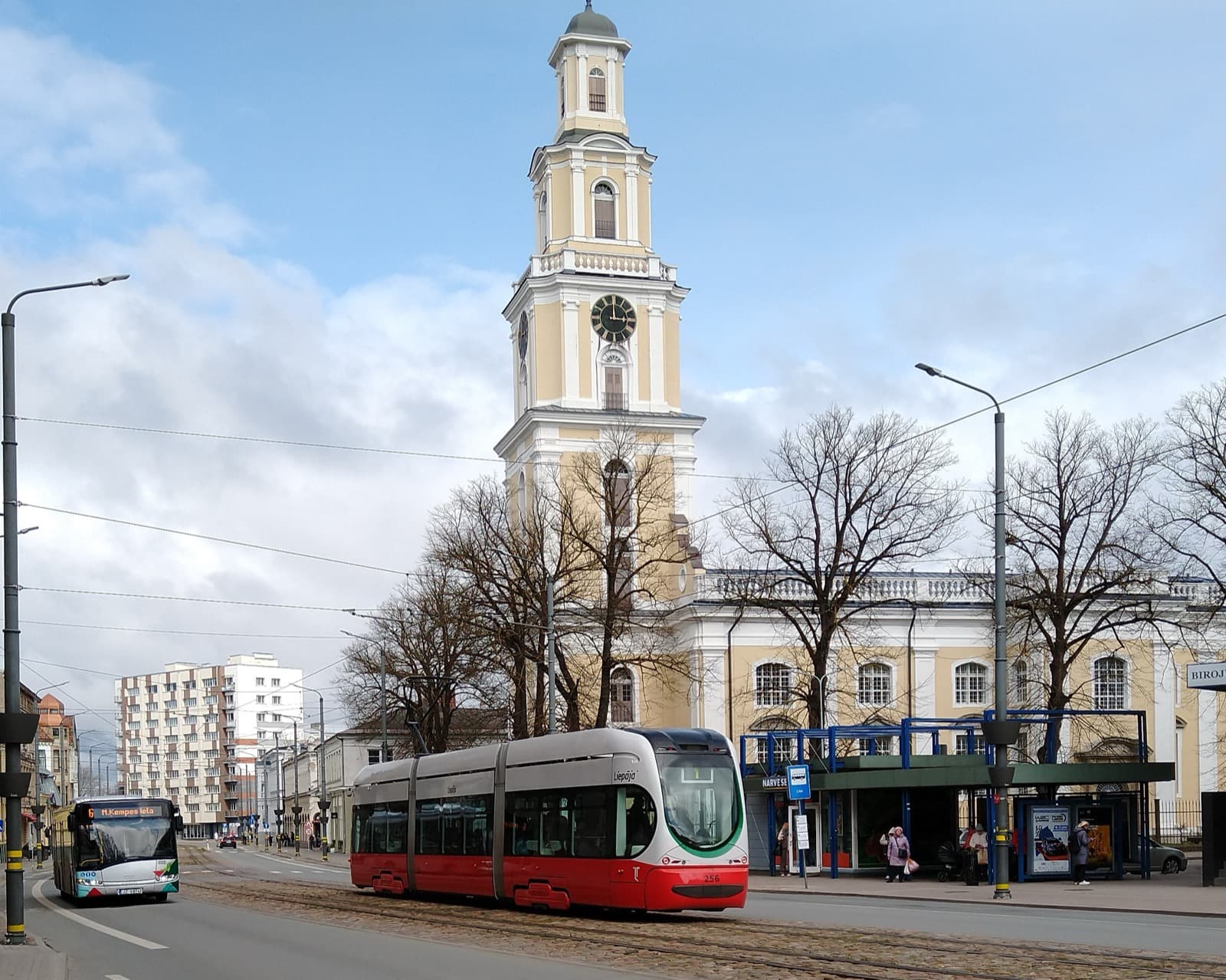 A red and white Liepāja tram passing the Holy Trinity Cathedral in the old centre of Liepāja, Latvia.