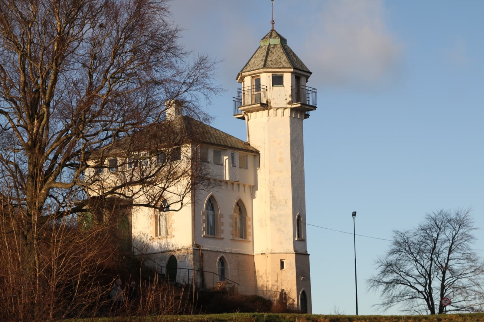The white Vålandstårnet lookout tower on the hilltop in low winter sunlight, Våland, Stavanger, Norway.
